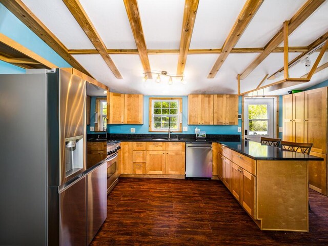 kitchen featuring dark wood-type flooring, appliances with stainless steel finishes, sink, and beamed ceiling