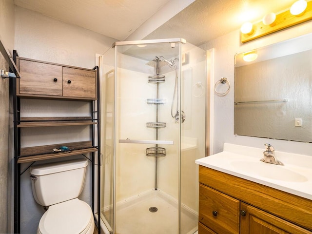 bathroom featuring a shower with door, vanity, and toilet