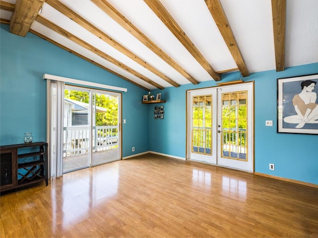 interior space with wood-type flooring, lofted ceiling with beams, french doors, and a healthy amount of sunlight