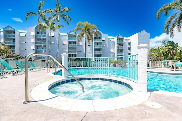 view of pool featuring a community hot tub and fence