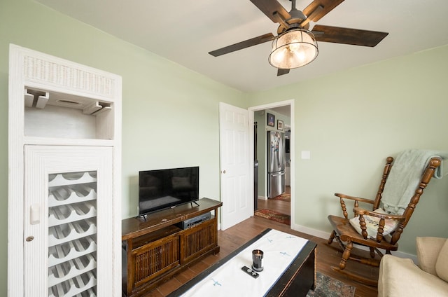 living room featuring ceiling fan and dark hardwood / wood-style flooring