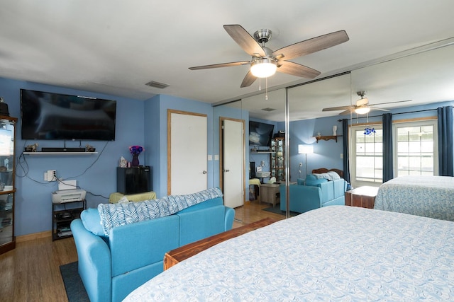 bedroom featuring dark wood-type flooring, ceiling fan, and a closet