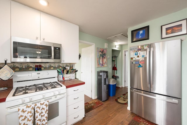 kitchen with white cabinetry, tile counters, stainless steel appliances, and dark hardwood / wood-style floors