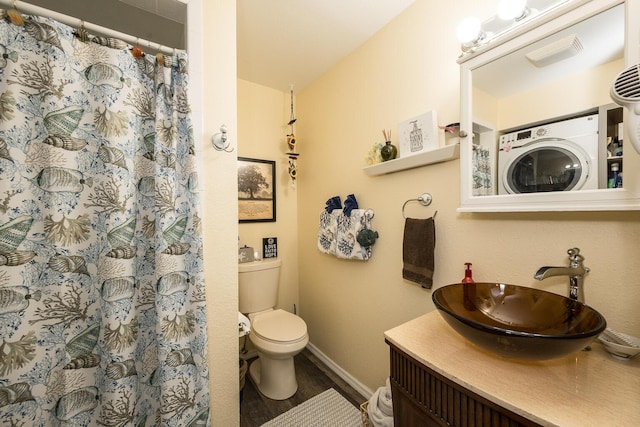 bathroom with a shower with curtain, vanity, toilet, and washer / dryer