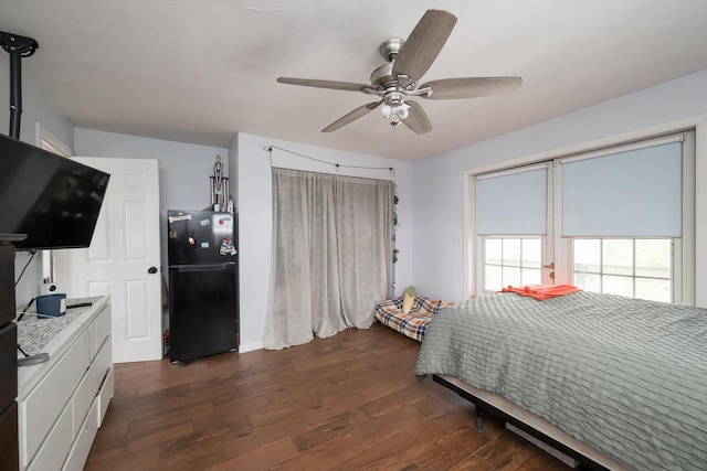 bedroom featuring a closet, dark hardwood / wood-style floors, ceiling fan, and black fridge