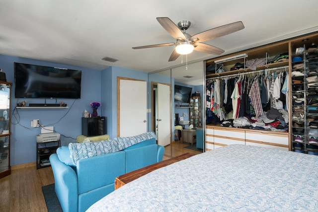 bedroom featuring hardwood / wood-style flooring, ceiling fan, and a closet