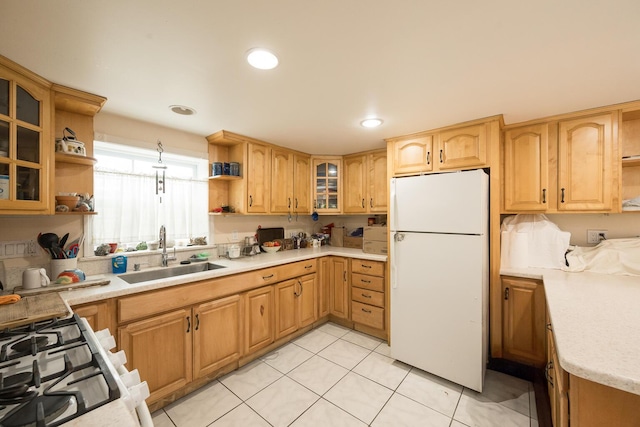 kitchen with sink, light tile patterned floors, and white refrigerator