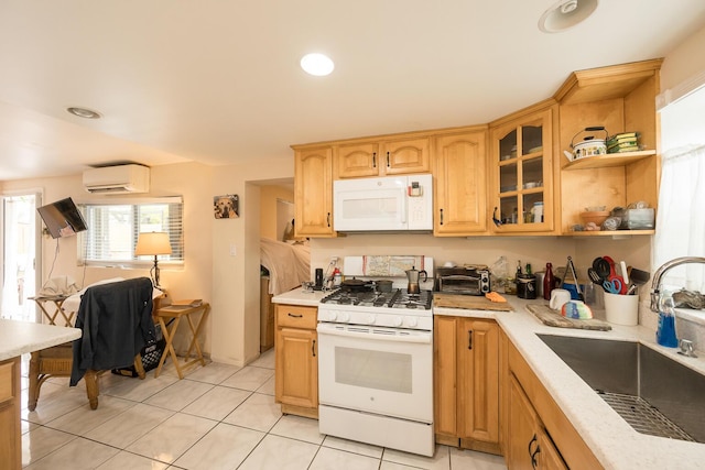 kitchen featuring white appliances, light tile patterned floors, sink, and an AC wall unit