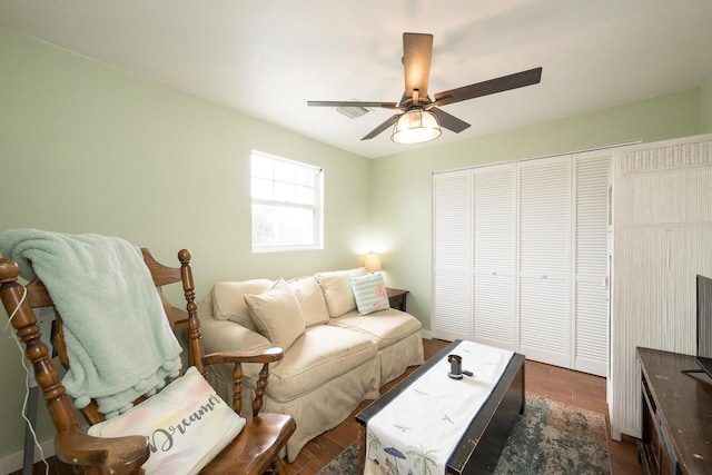 living room with ceiling fan and dark hardwood / wood-style flooring