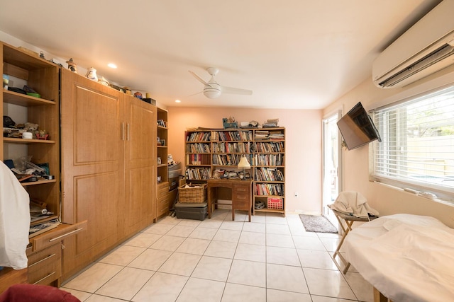 sitting room featuring light tile patterned floors, a wall unit AC, and ceiling fan