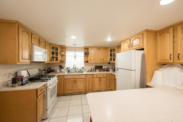 kitchen featuring white appliances, sink, and light tile patterned floors