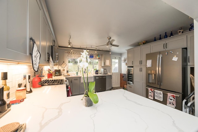 kitchen featuring gray cabinetry, black dishwasher, decorative backsplash, stainless steel fridge with ice dispenser, and decorative light fixtures