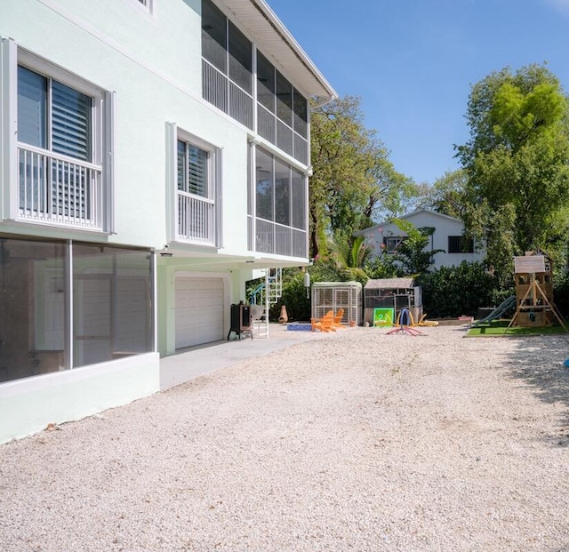 464 Lime Dr, Key Largo, FL 33037 - rear view of property with a garage, driveway, and stucco siding