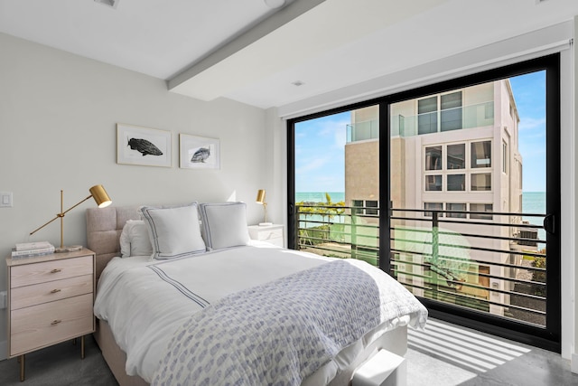 bedroom with beamed ceiling, a water view, and access to exterior