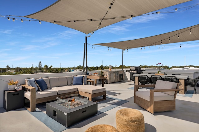 view of patio with area for grilling and an outdoor living space with a fire pit