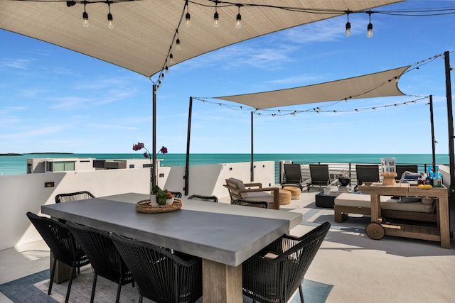 view of patio / terrace featuring a water view and a beach view