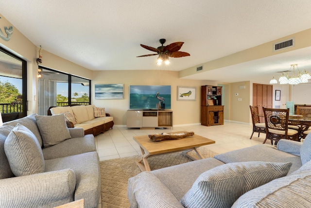 living room with ceiling fan with notable chandelier and light tile patterned floors