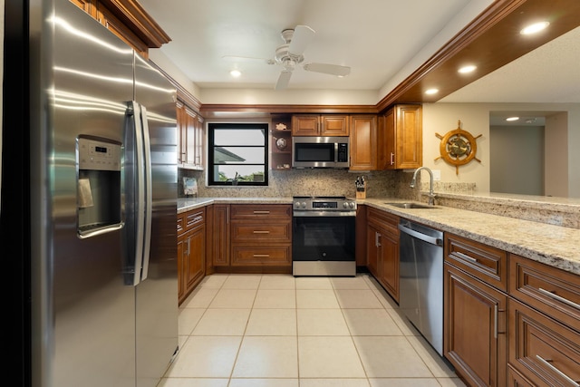 kitchen featuring sink, light tile patterned floors, appliances with stainless steel finishes, backsplash, and light stone countertops