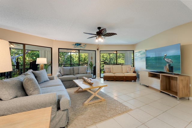 living room with ceiling fan, a textured ceiling, and light tile patterned floors