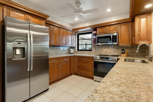 kitchen featuring backsplash, appliances with stainless steel finishes, sink, and light tile patterned floors