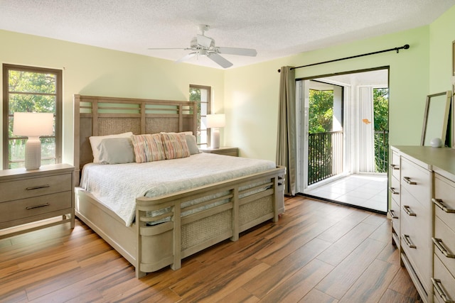 bedroom with wood-type flooring, access to exterior, and a textured ceiling