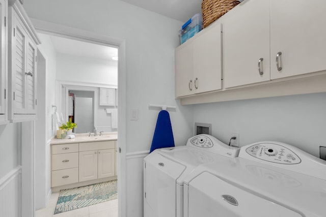 661 12th St, Key Colony, FL 33051 - laundry area featuring cabinet space, washing machine and clothes dryer, light tile patterned floors, and a wainscoted wall