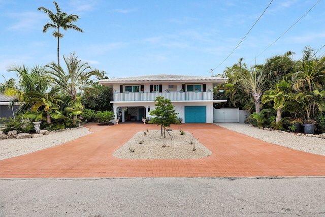 661 12th St, Key Colony, FL 33051 - coastal home featuring decorative driveway, stucco siding, stairs, an attached garage, and a porch
