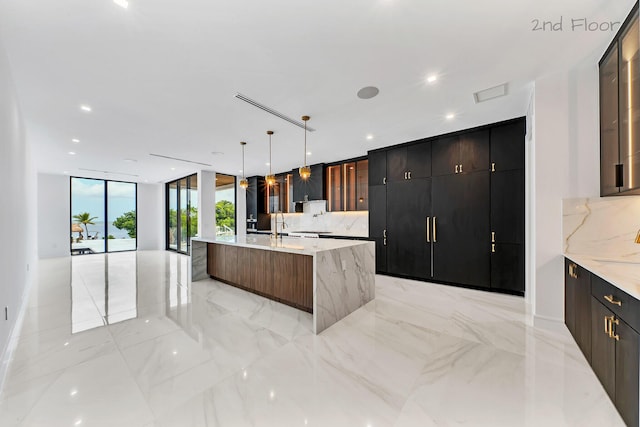 16 Seaside Ave, Key Largo, FL 33037 - kitchen featuring modern cabinets, tasteful backsplash, glass insert cabinets, pendant lighting, and expansive windows