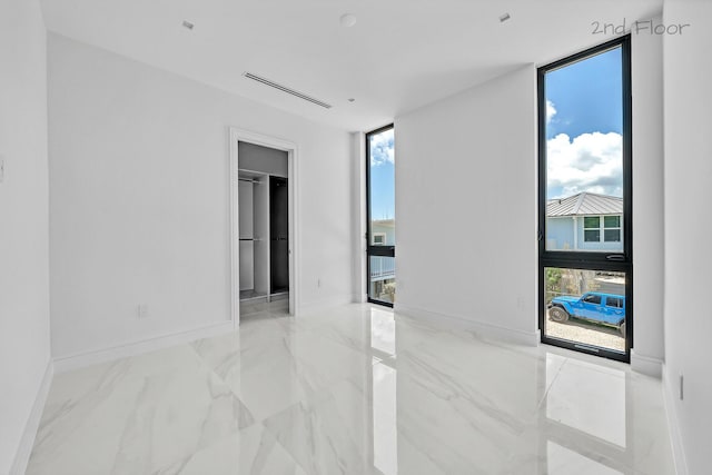 16 Seaside Ave, Key Largo, FL 33037 - unfurnished room featuring plenty of natural light, marble finish flooring, and baseboards