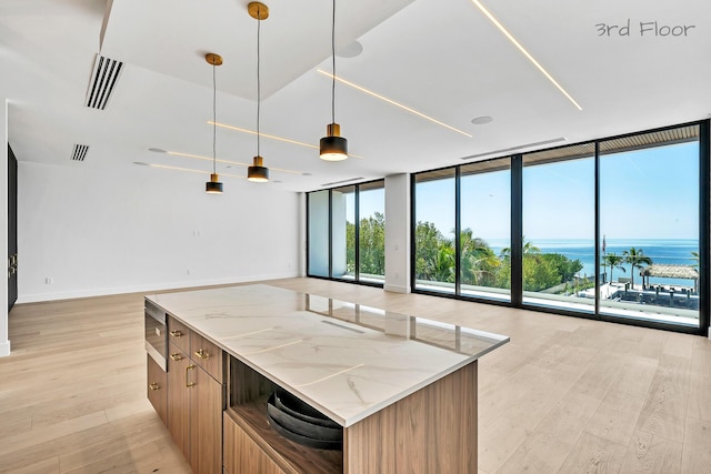 16 Seaside Ave, Key Largo, FL 33037 - kitchen with a wall of windows, open floor plan, light wood-type flooring, light stone counters, and pendant lighting