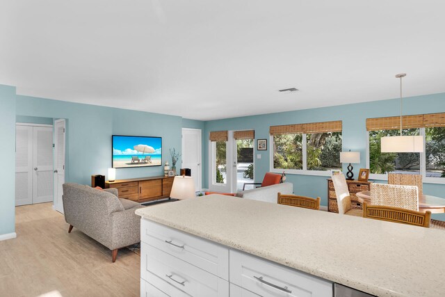 kitchen with pendant lighting, light wood-type flooring, and white cabinets