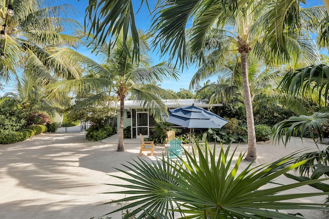 view of front of property featuring a sunroom and a patio