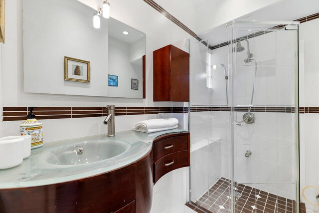 bathroom featuring vanity and a shower with shower door