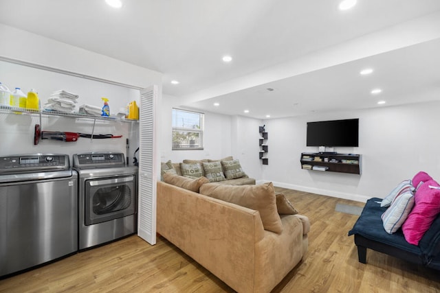 living room featuring independent washer and dryer and light wood-type flooring