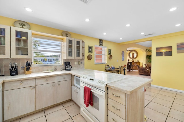 kitchen with tasteful backsplash, white appliances, tile counters, and kitchen peninsula