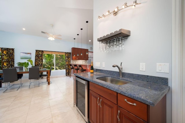 kitchen featuring decorative light fixtures, sink, wine cooler, dark stone counters, and ceiling fan