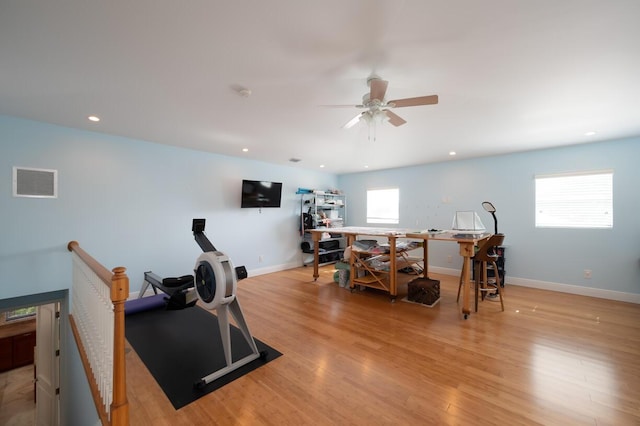 exercise area featuring ceiling fan, plenty of natural light, and light wood-type flooring