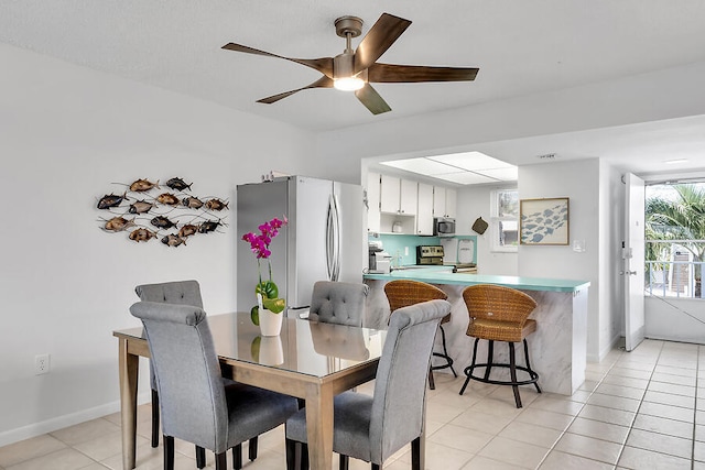 dining space featuring light tile patterned floors and ceiling fan