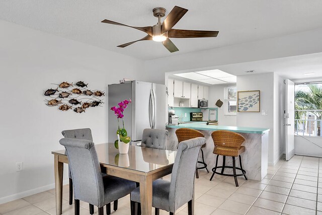 dining space featuring light tile patterned floors and ceiling fan