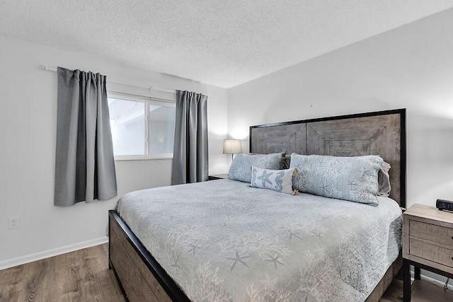 bedroom with dark wood-type flooring and a textured ceiling