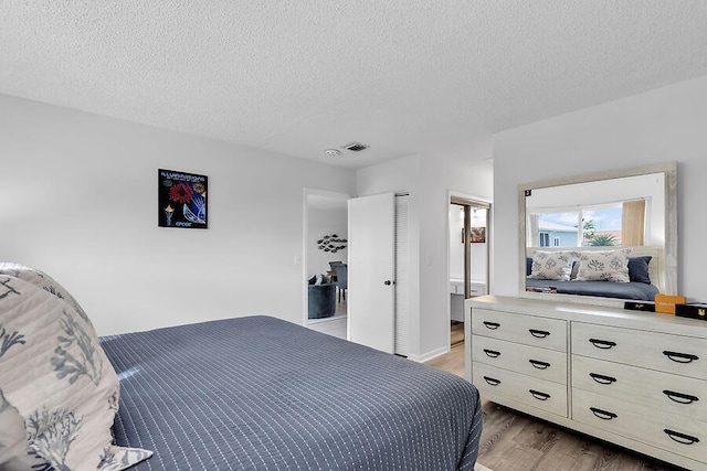 bedroom with a textured ceiling and light wood-type flooring