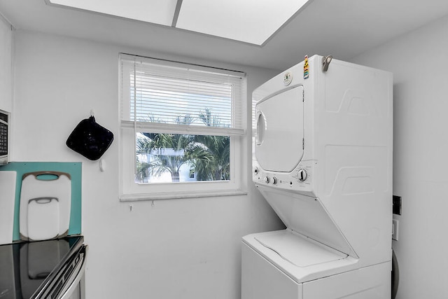 laundry room featuring stacked washer and clothes dryer and a healthy amount of sunlight