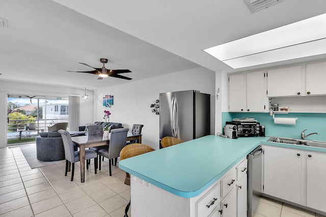 kitchen with sink, white cabinetry, light tile patterned floors, appliances with stainless steel finishes, and ceiling fan