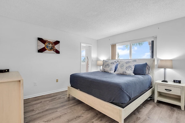 bedroom with hardwood / wood-style flooring and a textured ceiling