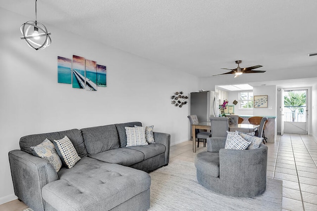 living room featuring light tile patterned floors, a textured ceiling, and ceiling fan