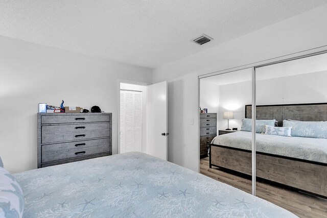 bedroom featuring a textured ceiling and light wood-type flooring