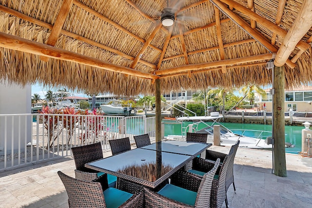 view of patio featuring a gazebo, ceiling fan, and a water view