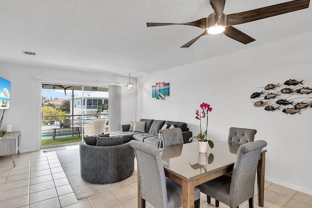 tiled dining space with ceiling fan