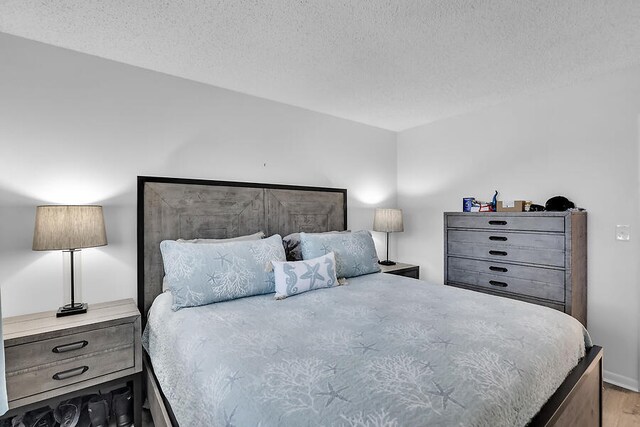 bedroom with light hardwood / wood-style flooring and a textured ceiling