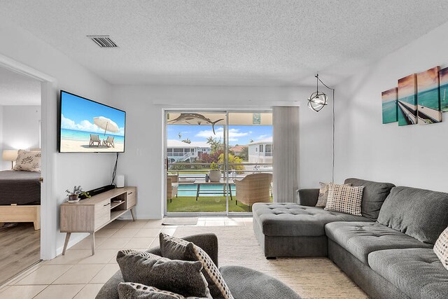 tiled living room featuring a textured ceiling